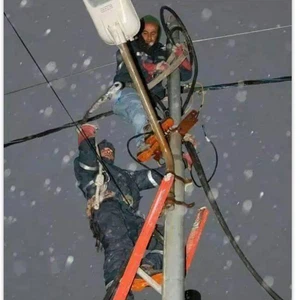 عمال الكهرباء يقومون بأداء واجبهم أثناء تساقط الثلوج