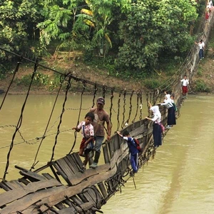 التلاميذ يمرون عبر جسر معلق ومهترئ في اندونيسيا