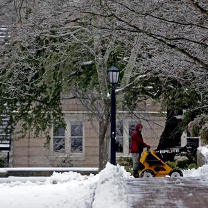 رجل يعمل على إزالة الثلوج من أمام منزله 