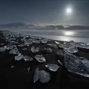الرمال البركانية السوداء على هذا الشاطئ الايسلندي تتناقض بشكل جميل مع قطع الجليد البيضاء والزجاجية.