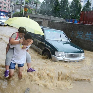 صورا لأشخاص يحالون السير  في مياه الفيضانات