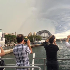 أشخاص يلتقطون صورا للسحب المرافقة للعاصفة 