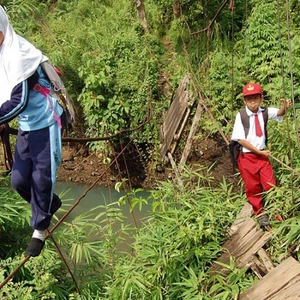 يتمسكون بحبل الجسر المهترئ للوصول الى المدرسة في اندونيسيا