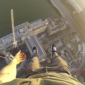 فيديو مثير : مُغامر يتعلق بيد واحدة من على أحد أبنية لندن الشاهقة .. 