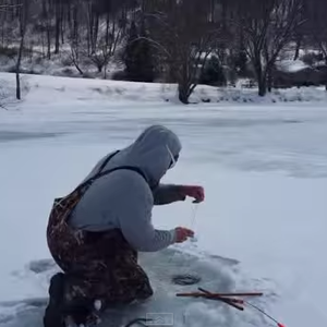 صياد سمك يصطاد طائرا مائيا من تحت الجليد بدلا من السمك 