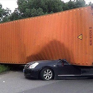 بالصور: صينية تنجو من الموت رغم سقوط حاوية نقل ضخمة على سيارتها 