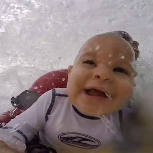 أب مُتهور يمارس ركوب الأمواج بصحبة ابنه ذو التسعة أشهر 