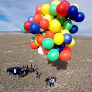 مغامر يطير جالساً باستخدام 90 بالون هيليوم