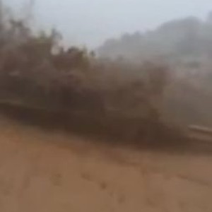 سعودي يعرض حياته للخطر ويقف معترضاً لمجرى السيول في عسير