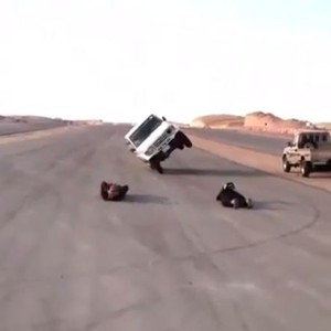 سعوديان مُتهوران يرقدان على الطريق تحت سيارة تسير على عجلتين 