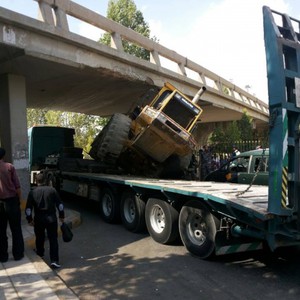 بالصور: جرافة عالقة تحت جسر صويلح 