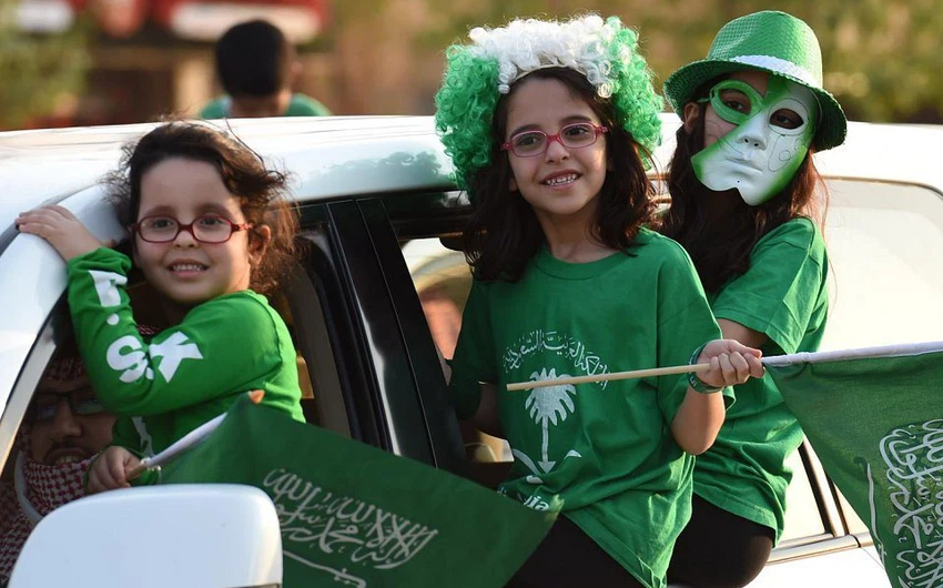 طفلات سعوديات يحملن العلم السعودي