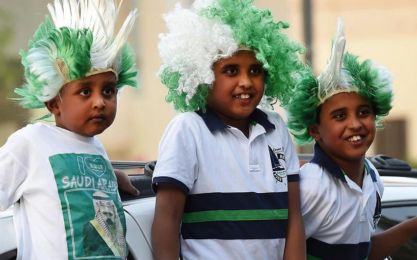 أطفال يرتدون قبعات بلون العلم السعودي
