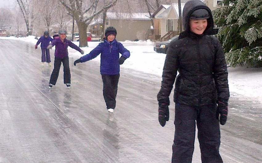 أطفال يستخدمون الشارع كحلبة تزلج من شدة الجليد