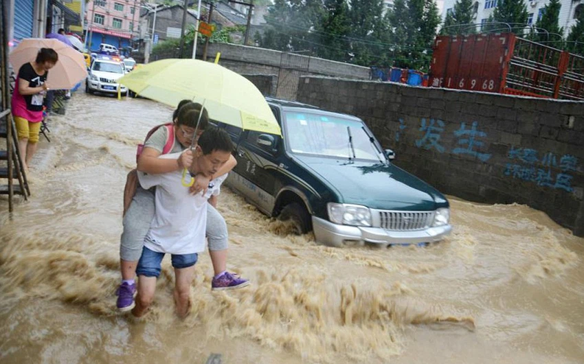 صورا لأشخاص يحالون السير  في مياه الفيضانات