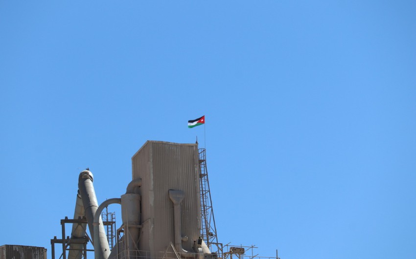 The flag of Jordan is raised over the cement factory in Al-Rashadiya to celebrate the Flag Day