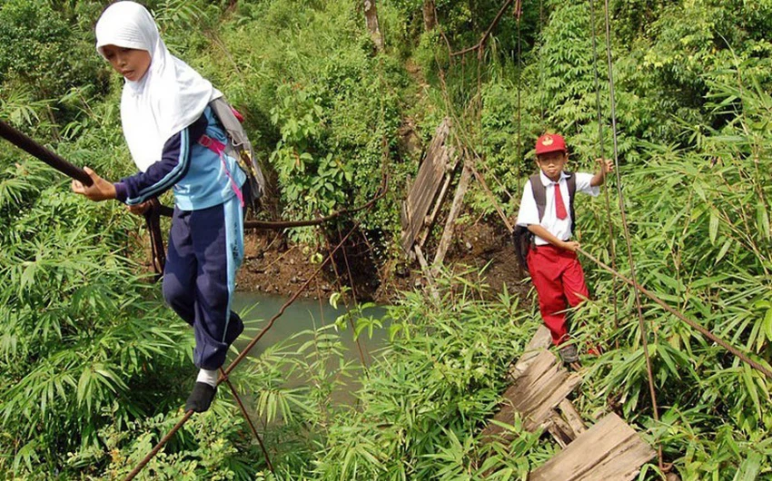 يتمسكون بحبل الجسر المهترئ للوصول الى المدرسة في اندونيسيا